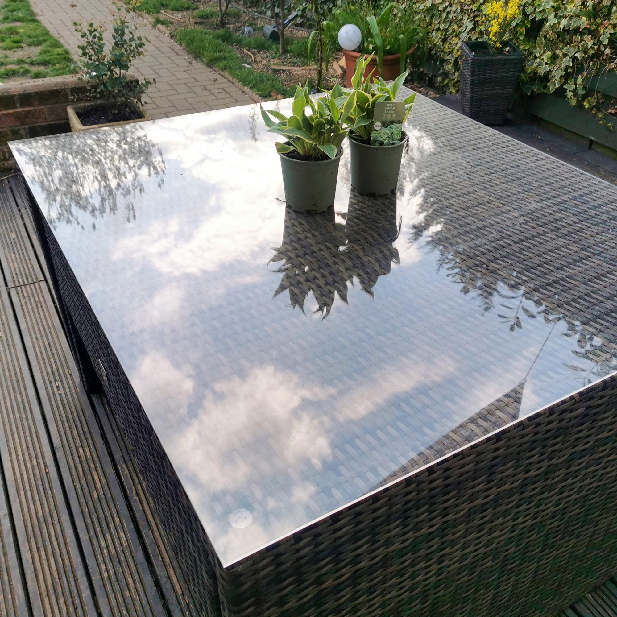square clear acrylic table protector on a garden table