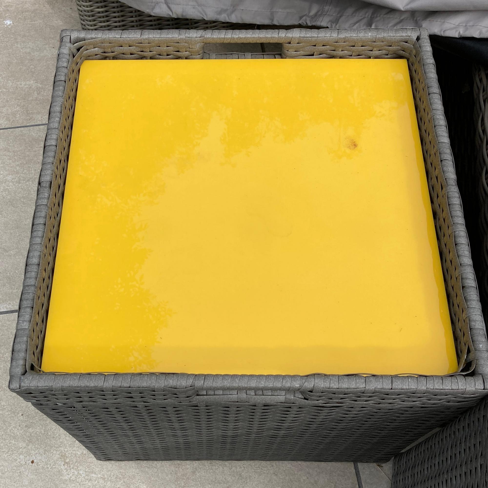 yellow acrylic table protector on a garden table