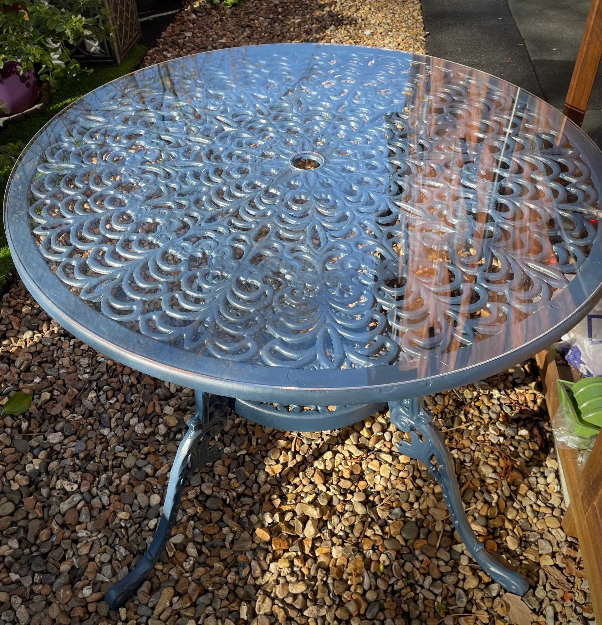 circular clear acrylic table protector on a garden table