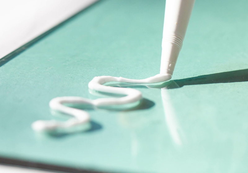 adhesive being applied to acrylic sheet