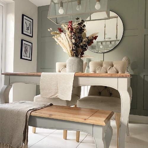 Grey wall panelling in background with a cream painted table in the foreground