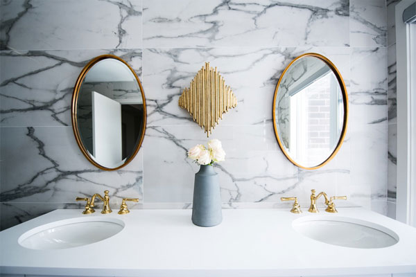 Clean white bathroom with large round mirrors