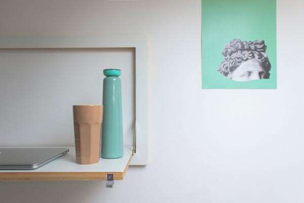 White wall with thin pale plywood shelves